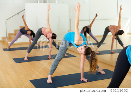Sporty females doing stretching and incline workout Sporty females doing stretching and incline workout 90111692