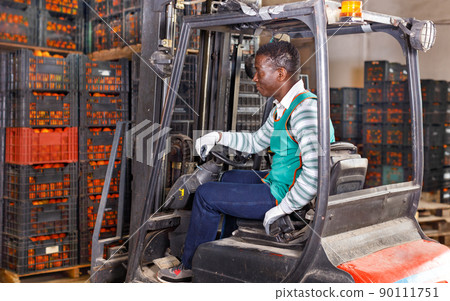 African American man using forklift on mandarins warehouse African American man using forklift on mandarins warehouse 90111751