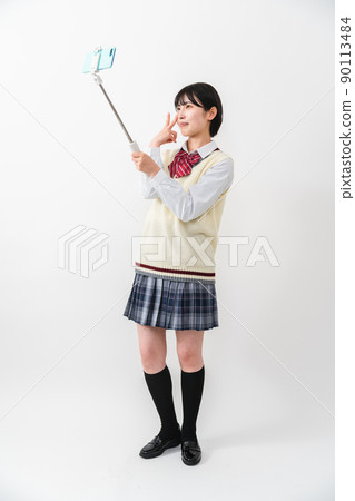High school girls taking selfies with their smartphones High school girls taking selfies with their smartphones 90113484