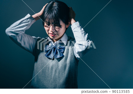 High school girl holding her head 90113585