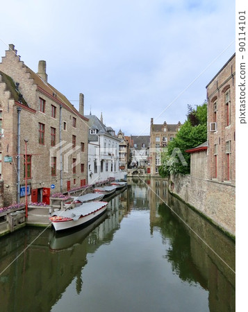 Brick houses in Bruges, Belgium and boats floating on the canal vertical size Brick houses in Bruges, Belgium and boats floating on the canal vertical size 90114101