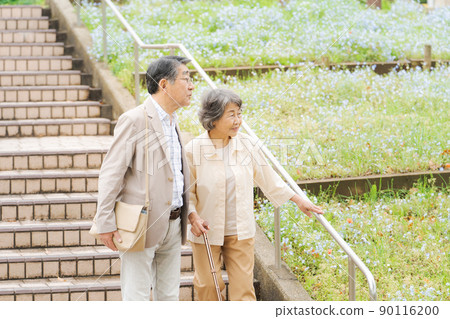 Senior couple going down the stairs outdoors 90116200