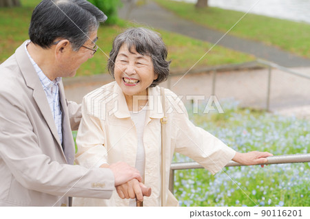 Senior couple going down the stairs outdoors 90116201