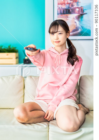 一個年輕的女人在看電視 90117336