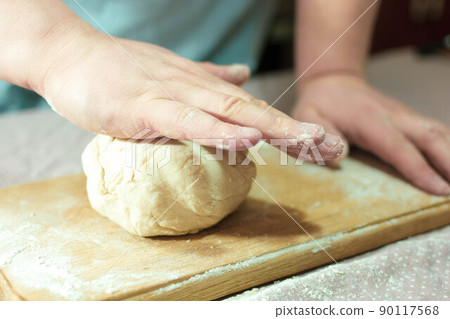 Knead the dough on a wooden board at home 90117568