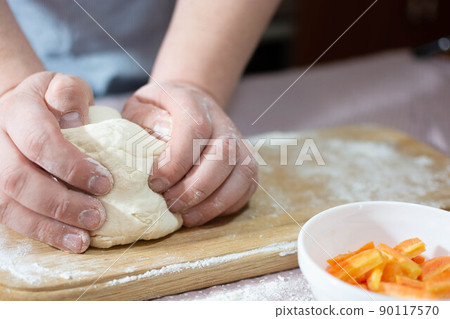 Knead the dough on a wooden board at home 90117570