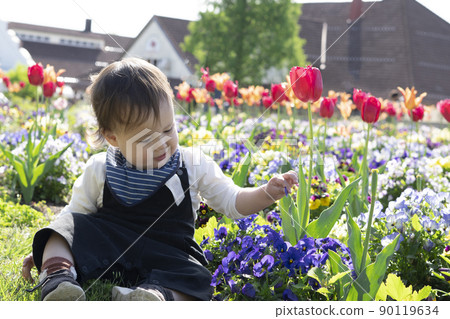Half-boy touching flowers in a flower field 90119634