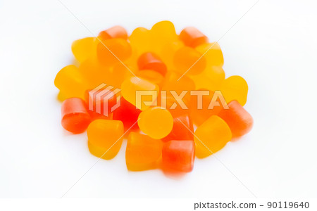 Close-up texture of orange and yellow multivitamin gummies in the form of bears on white background. Close-up texture of orange and yellow multivitamin gummies in the form of bears on white background. 90119640