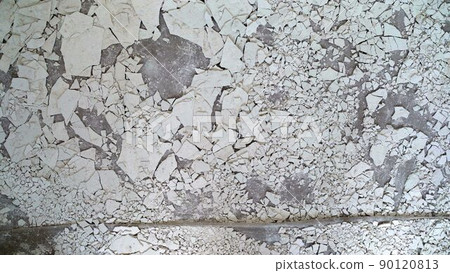 The crumbling white plaster from the ceiling lies on the floor. Old, cracked putty on the floor. 90120813