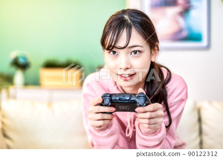 Young woman playing online games Young woman playing online games 90122312