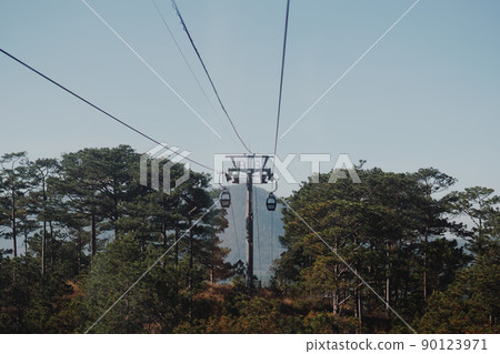 Circulating cable car between Dalat bus station and Robin Hill Truc Lam Vietnam. Intermediate support tower. Picturesque landscape view. Pine forest tree tops, clear sky. Evening mood. Collection Circulating cable car between Dalat bus station and Robin Hill Truc Lam Vietnam. Intermediate support tower. Picturesque landscape view. Pine forest tree tops, clear sky. Evening mood. Collection 90123971