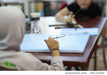 Child draws with brush and draws picture closeup 90124204