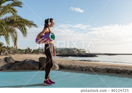 Beautiful sporty woman ready to exercise in front of the beach. Beautiful sporty woman ready to exercise in front of the beach. 90124725