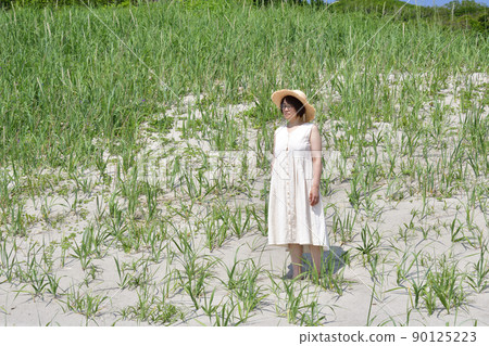 Taking a portrait of a woman on the sandy beach of Kumaishi, Yakumo-cho, Hokkaido in early summer Taking a portrait of a woman on the sandy beach of Kumaishi, Yakumo-cho, Hokkaido in early summer 90125223
