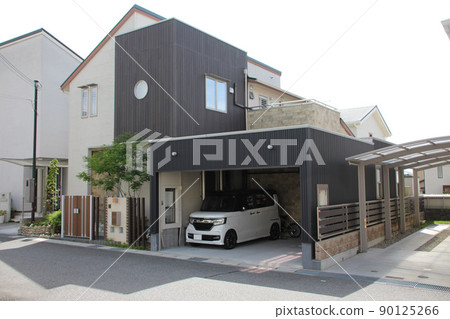 A beautiful mansion with a dark vertical plank-shaped cube, a pale outer wall with a one-sided roof, and a black aluminum spandrel carport. 90125266