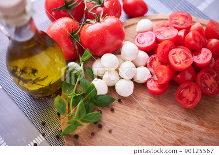 Ingredients for Caprese salad - Mini mozzarella cheese in glass bowl, tomato and basil 90125567