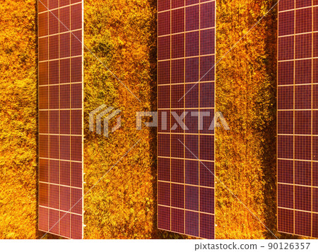 Aerial top view of a solar panels power plant. Photovoltaic solar panels at sunrise and sunset in countryside from above. Modern technology, climate care, earth saving, renewable energy concept. 90126357