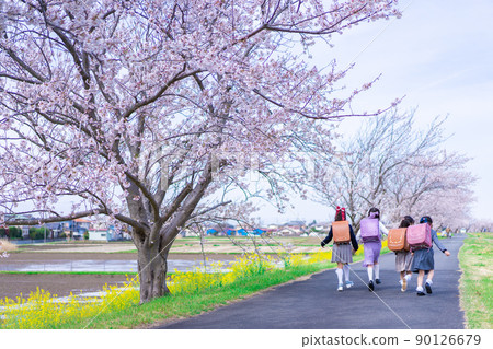 Elementary school girls carrying school bags on their backs and having fun going to school 90126679