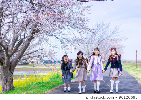Elementary school girls carrying school bags on their backs and having fun going to school 90126683