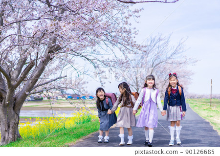 Elementary school girls carrying school bags on their backs and having fun going to school 90126685
