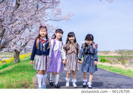 Elementary school girls carrying school bags on their backs and having fun going to school 90126700