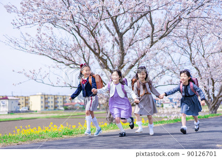 Elementary school girls carrying school bags on their backs and having fun going to school 90126701
