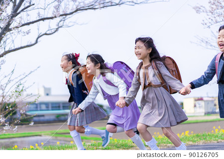 Elementary school girls carrying school bags on their backs and having fun going to school 90126705