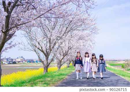 Elementary school girls carrying school bags on their backs and having fun going to school 90126715