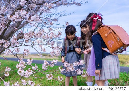 Elementary school girls carrying school bags on their backs and having fun going to school 90126717