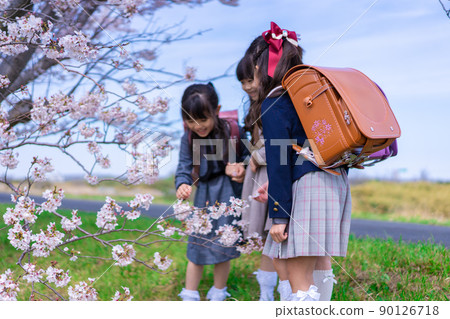 Elementary school girls carrying school bags on their backs and having fun going to school 90126718