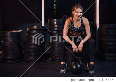 Woman working out with kettle ball at gym 90126827