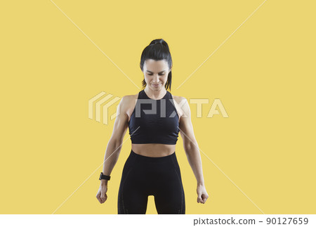 Sportive toned woman in sportswear on yellow background 90127659