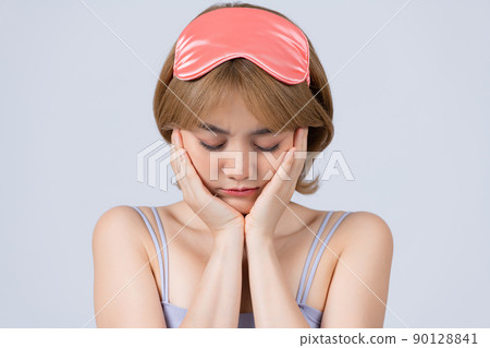Studio shot of pleased beautiful young woman posing in eyemask. Studio shot of pleased beautiful young woman posing in eyemask. 90128841