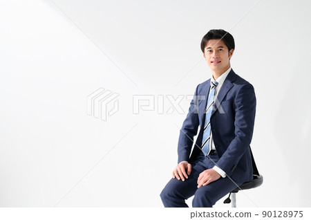 A businessman man sitting in a chair with a smile 90128975