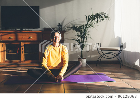 Young caucasian brunette woman practicing yoga at home sitting in lotus pose. Mindfulness meditation concept. 90129368