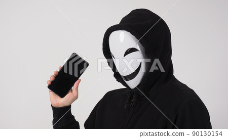 Anonymous hacker and face mask with smartphone in hand. Man in black hood shirt holding and using mobile phone on white background. Represent cyber crime data hacking or stealing personal data concept 90130154