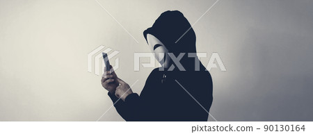 Anonymous hacker and face mask with smartphone in hand. Man in black hood shirt holding and using mobile phone on white background. Represent cyber crime data hacking or stealing personal data concept 90130164
