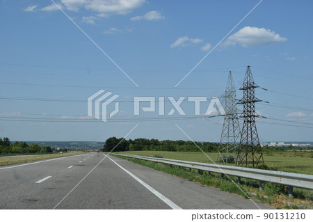 High voltage transmission towers, where many wires, have a clear sky background. 90131210
