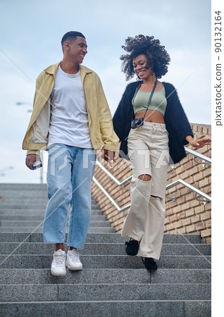Guy and girl going down stairs on street Guy and girl going down stairs on street 90132164