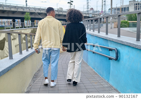 Back view guy and girl walking hand in hand Back view guy and girl walking hand in hand 90132167