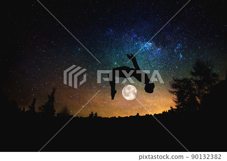 sporty man jumping against the night starry sky background. Mixed media sporty man jumping against the night starry sky background. Mixed media 90132382