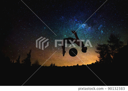 sporty man jumping silhouette at the night starry sky and moon background. sporty man jumping silhouette at the night starry sky and moon background. 90132383