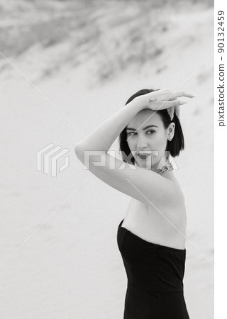 girl in a black long dress in a sandy desert 90132459