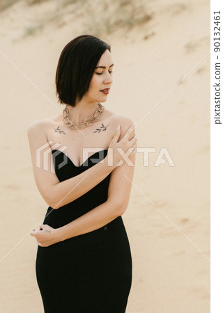girl in a black long dress in a sandy desert girl in a black long dress in a sandy desert 90132461