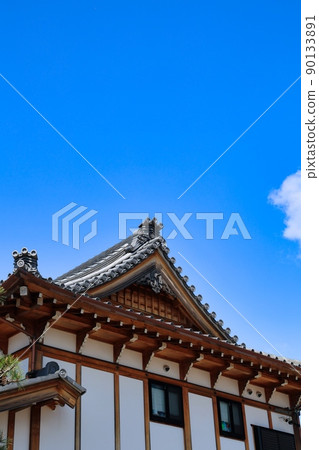 Clear blue sky and tiled roof of old building 90133891