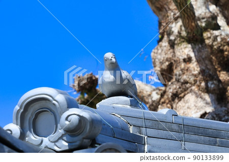 Clear blue sky and tiled roof of old building 90133899