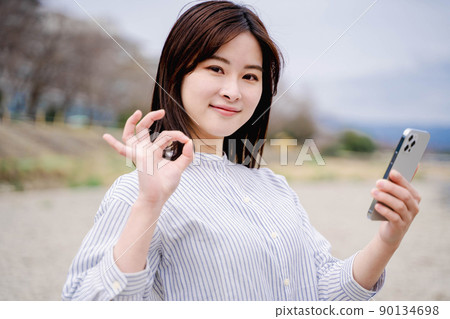 Outdoor portrait of a young woman smartphone Outdoor portrait of a young woman smartphone 90134698
