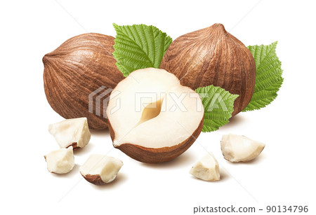 Hazelnuts without nutshell with small broken pieces and leaves. 90134796