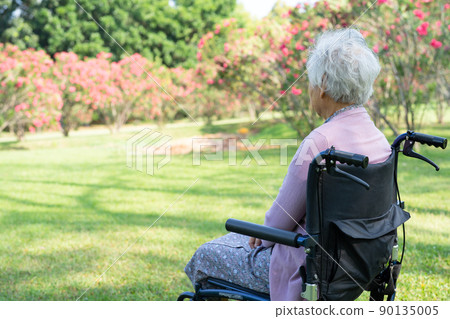 Asian senior or elderly old lady woman patient sitting and happy on wheelchair in park, healthy strong medical concept. Asian senior or elderly old lady woman patient sitting and happy on wheelchair in park, healthy strong medical concept. 90135005