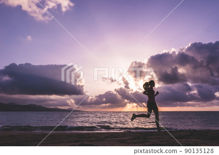 Young woman running on las canteras  beach at sunset. Las Palmas de Gran Canaria, Spain. Runing and health care concept. 90135128